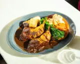 Pyszny niedzielny obiad: pieczone udka kurczaka w sosie, pieczone ziemniaki, brokuły i kalafior zapiekany w Yorkshire pudding.