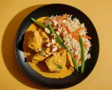 Aksamitny kurczak curry w kremowym sosie, podany z ryżem basmati, fasolką szparagową i płatkami migdałów.