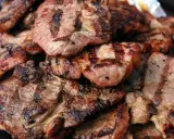 Soczysta karkówka z grilla, idealna marynata do karkówki na grilla okrasa. Grillowane plastry mięsa z charakterystycznymi paskami.