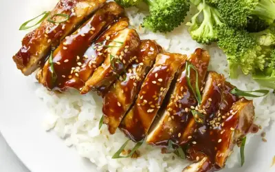 Pyszny teriyaki kurczak w sosie, podany z ryżem i brokułami. Posypany sezamem i szczypiorkiem.