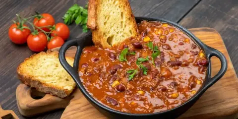 Gęste chili con carne z fasolą i kukurydzą, podane z chrupiącym pieczywem. Idealny obiad na dwa dni, który rozgrzeje i nasyci.