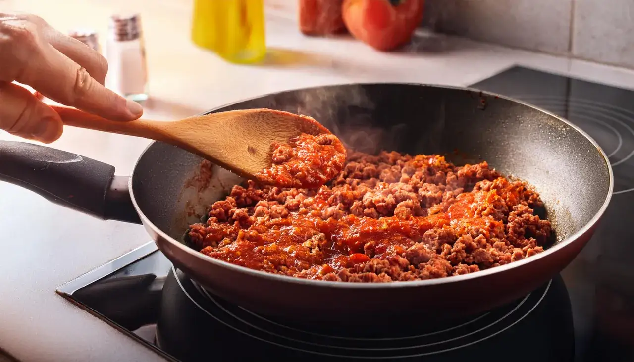 Mielone mięso z sosem pomidorowym na patelni, idealne jako baza do sosu bolognese. Dobre jakie mięso do spaghetti? To właśnie ono!