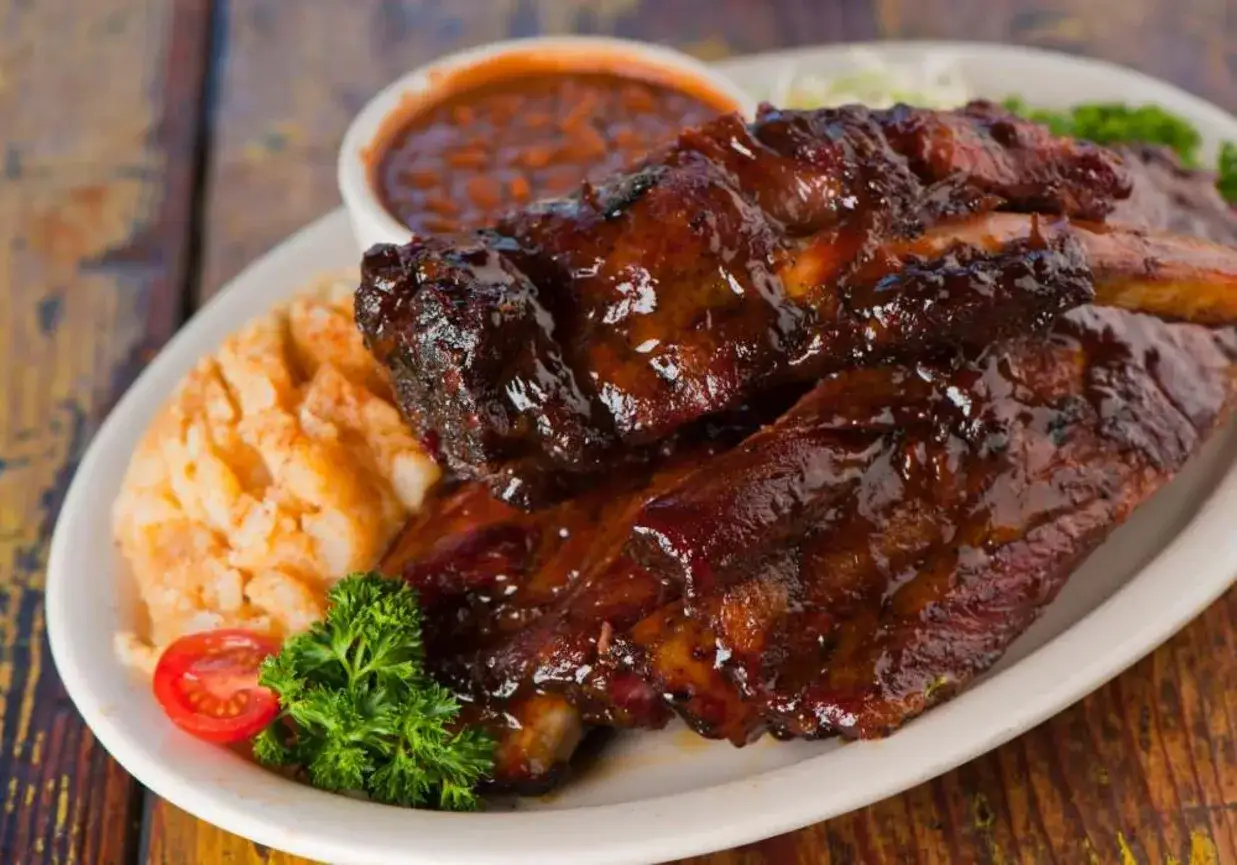 Soczyste żeberka w sosie BBQ, podane z puree ziemniaczanym i fasolką. Idealna marynata do żeberek sprawia, że mięso jest kruche i aromatyczne.